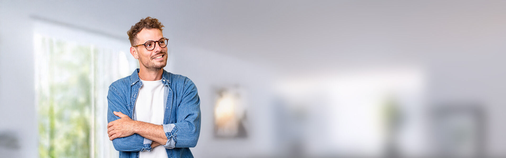 ein Mann in einem blauen Hemd und einer Brille, die an eine Wand gelehnt ist