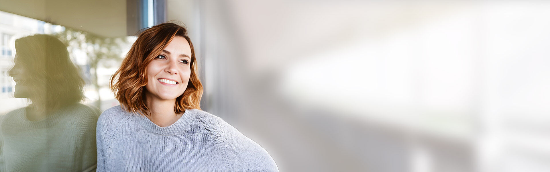 eine Frau, die vor einem Fenster steht