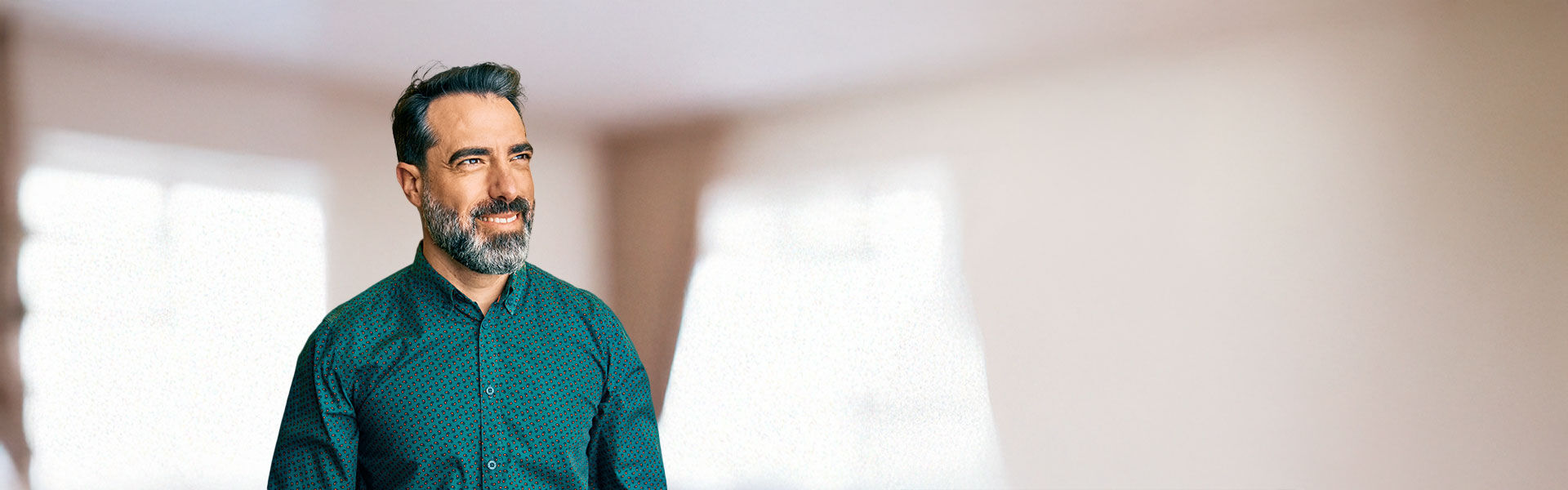 ein Mann mit Bart, der in einem Raum steht