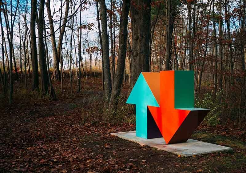 Ein grüner Pfeil und ein roter Pfeil nach unten stehen nebeneinander im Wald.