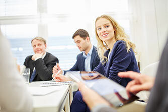 eine Gruppe von Menschen, die um einen Tisch sitzen